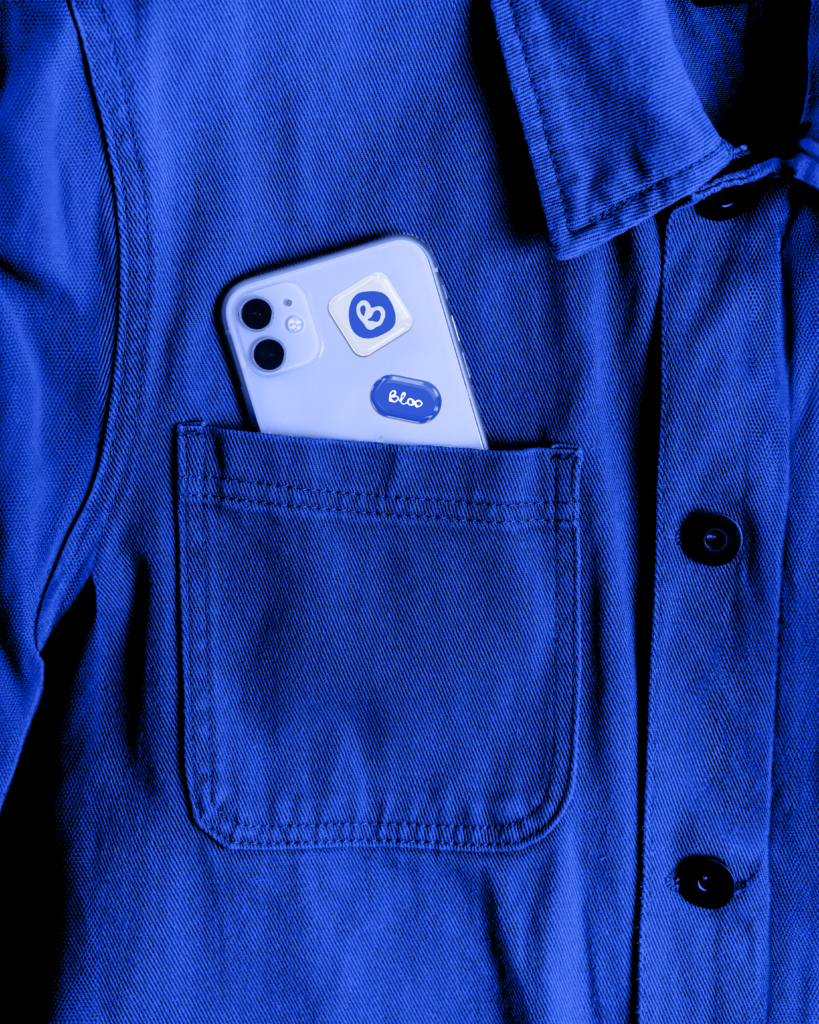 Stickers de la marque Bloo sur un téléphone, dans une veste bleue évoquant un style de vie actif et urbain
